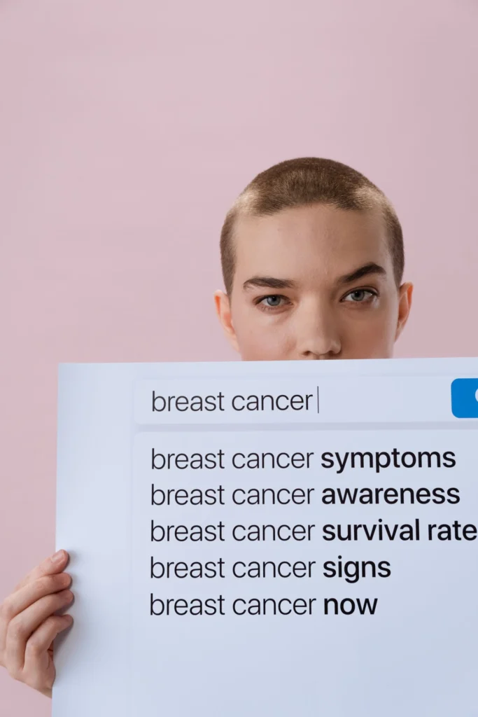 Donna con rasata sfondo rosa, in mano pagina di ricerca di browser e parole chiave in inglese