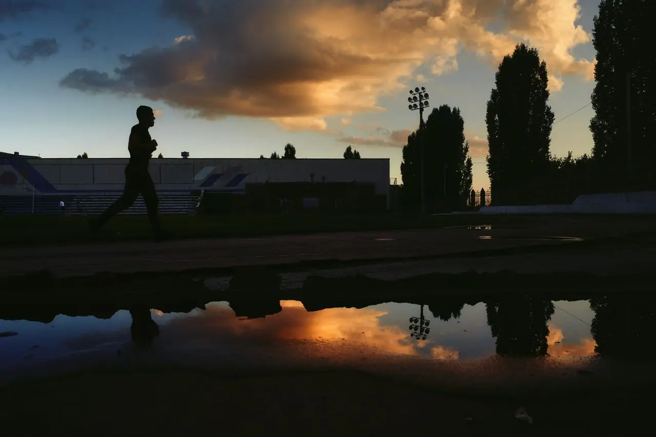 uomo corre al tramonto all'aperto in città