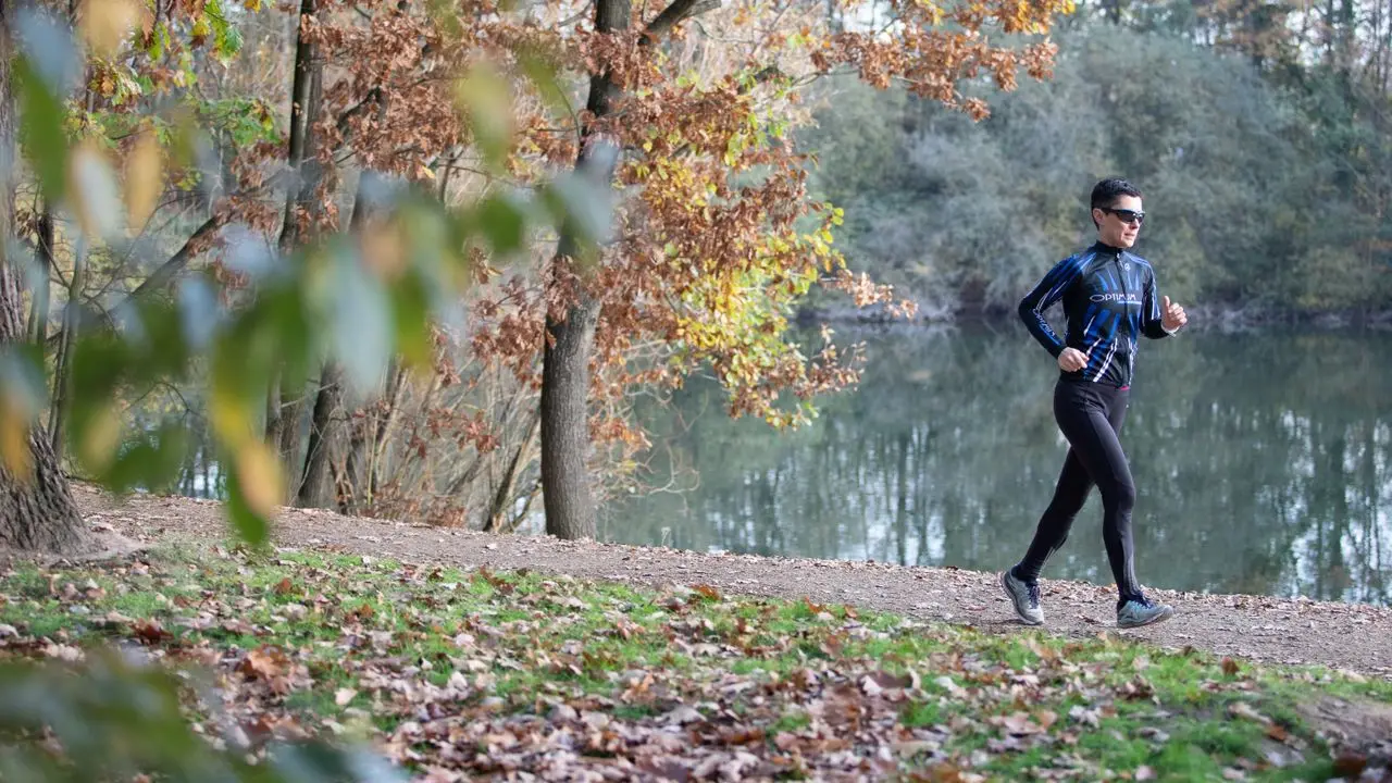 donna corre nel parco con abbigliamento tecnico