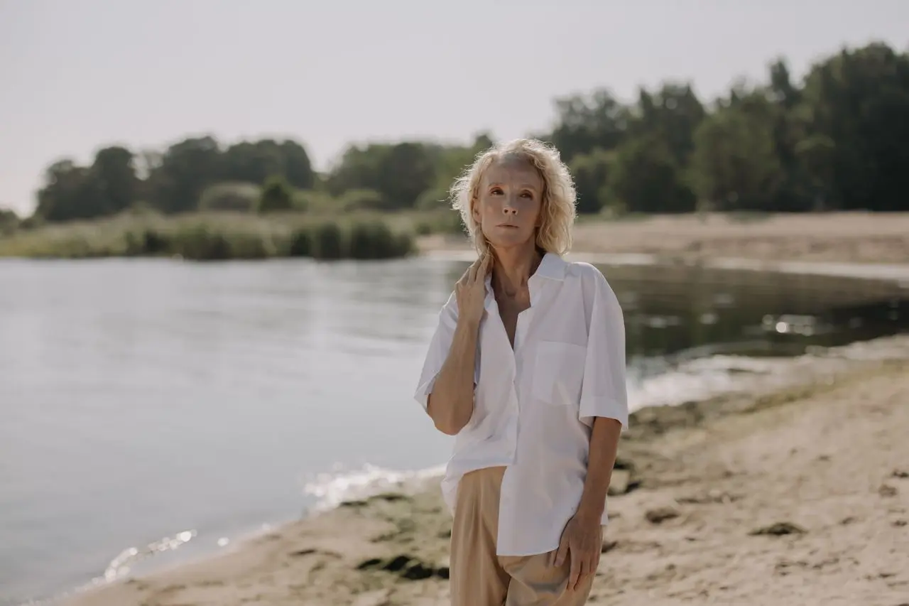 donna dopo menopausa, sulla spiaggia pensierosa