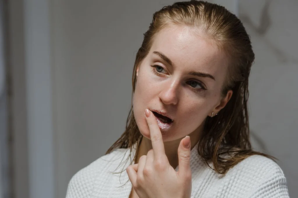 ragazza che applica sulle labbra un particolare prodotto sanante