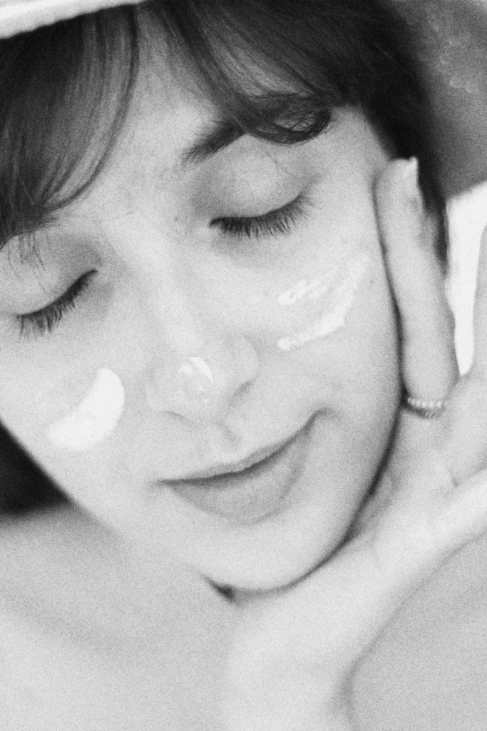 donna che ha applicato crema sul viso, socchiude gli occhi