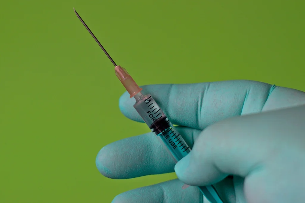 vaccino antinfluenzale, mano con siringa pronta 